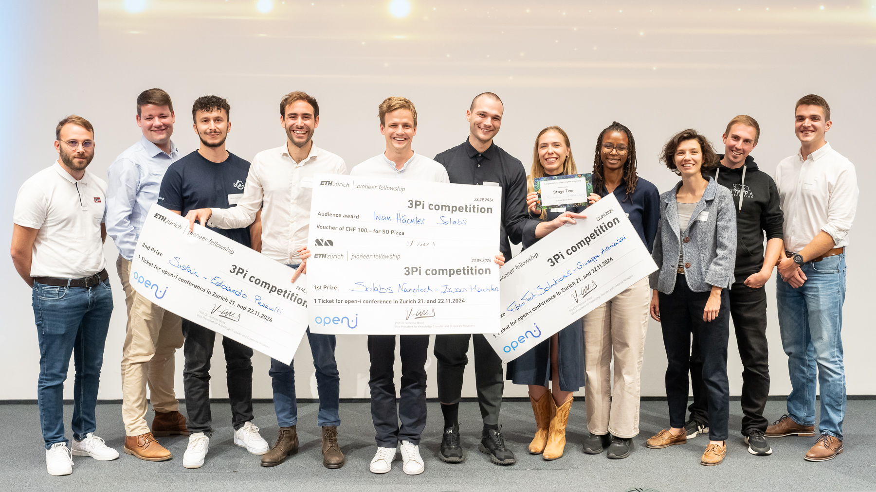 3Pi Competitors , a group of eleven smiling young people holding up their price banners
